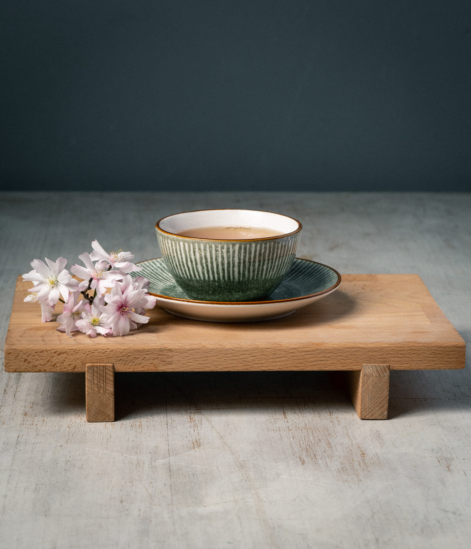 Eine Tasse Grüner Tee mit Kirschblüten